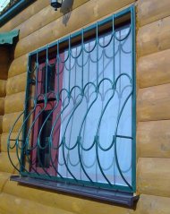 Металлическая решетка на деревянном доме