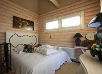 Оформление спальни в домах из бревна ничем не отличается: светлые,  спокойные тона и несколько цветовых акцентов